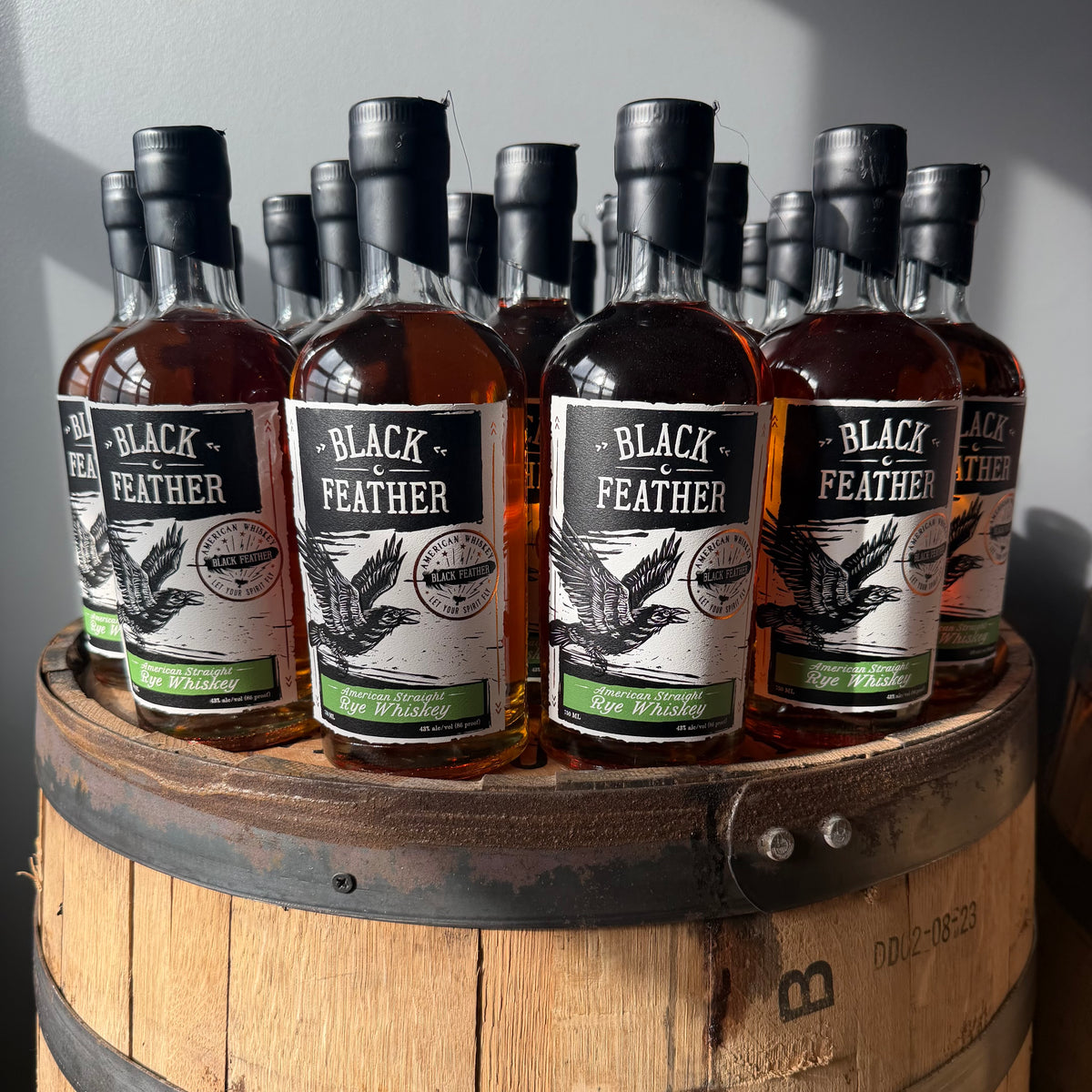 Black Feather rye whiskey bottles on a barrel at the SLC bottle shop